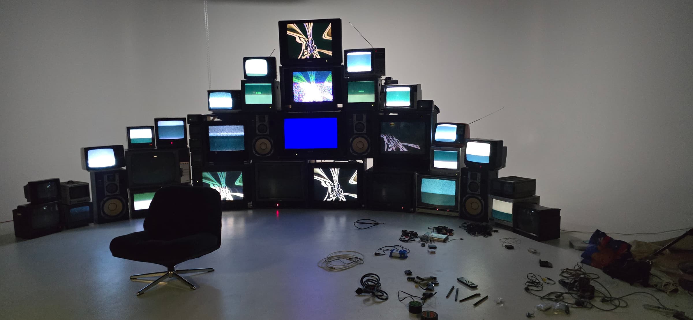 Mur de téléviseurs cathodiques installé dans une salle sombre